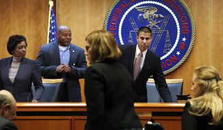 Federal Communications Commission (FCC) Chairman Ajit Pai (right) and Commissioner Mignon Clyburn (far left) were asked to leave by a member of security as the meeting room is evacuated where the Federal Communications Commission was about to vote on net neutrality Thursday. (Associated Press)