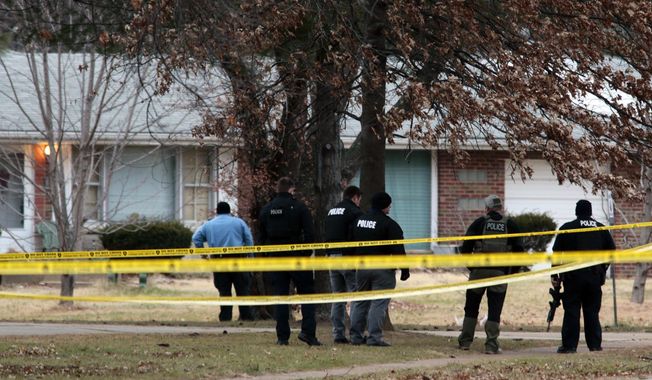 CORRECTS TO BELLEFONTAINE NEIGHBORS POLICE SHOT, NOT ST. LOUIS COUNTY AND UPDATED CAPTION INFORMATION - Police officers work the scene where two  Bellefontaine Neighbors officers were shot and a man barricaded himself inside a home on Thursday, Dec. 14, 2017, in the St. Louis County town of Bellefontaine Neighbors, Mo. Bulletproof vests saved both officers from serious injury. A suspect was taken into custody after a standoff that lasted more than seven hours. (Robert Cohen/St. Louis Post-Dispatch via AP)