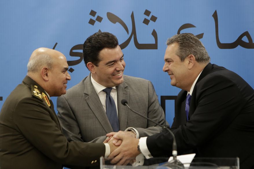 Cyprus' Defense Minister Christoforos Fokaides, center, shakes hands with his Greek counterpart Panos Kammenos, right, and Egyptian Defense Minister Sedki Sobhi after their first of three-way talks at the "Zenon" Search and Rescue Coordination Center next to Cyprus' Larnaca international airport, on Thursday, Dec. 14, 2017. The defense ministers of Cyprus, Egypt and Greece have agreed to step up cooperation in combatting drug, weapons and people trafficking in the east Mediterranean and to share information on countering the threat of terrorism. (AP Photo/Petros Karadjias)
