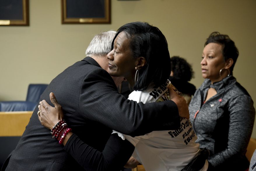 Zenobia Dobson hugs Assistant District Attorney Phil Morton Thursday, Dec. 14, 2017, in Knoxville, Tenn., after a jury convicted Christopher Bassett of first degree murder and Kipling Colbert Jr. and Gregory Williams III of facilitation in the killing of her son Zaevion Dobson. (Michael Patrick/Knoxville News Sentinel via AP)