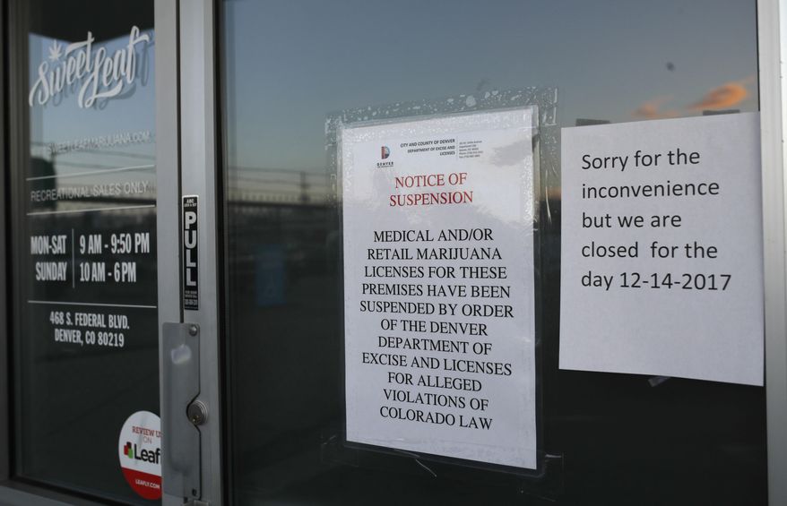 Closed signs are displayed on the front door to a marijuana dispensary along South Federal Boulevard Thursday, Dec. 14, 2017, in south Denver. Twenty-six legal marijuana businesses were closed by Denver officials Thursday amid a police investigation expected to lead to criminal charges. (AP Photo/David Zalubowski)