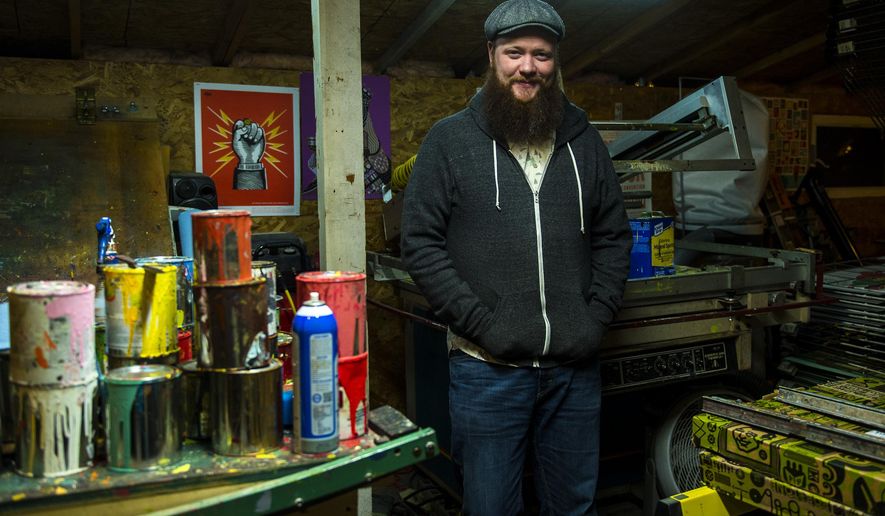 In this Tuesday, Nov. 28, 2017 photo, artist Travis Bone poses for a portrait in his workshop in Midvale, Utah. His posters, sold under the brand Furturtle, are often found alongside standard T-shirt options at shows from Red Butte Garden to the Twilight Concert Series to Kilby Court and more. Each poster is unique, designed for a single show. (Chris Detrick/The Salt Lake Tribune via AP)