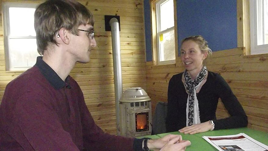 In this July 18, 2017, photo, Allison Rohrs, director for the Institute of Energy at Saint Francis University, and project coordinator Mike Sell talk in a 160-square-foot tiny classroom fueled by renewable energy on the campus in Loretto, Pa. Saint Francis' tiny classroom was built in a shell purchased from 84 Lumber. (Russ O'Reilly/Altoona Mirror via AP)