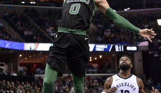 Boston Celtics forward Jayson Tatum (0) dunks the ball ahead of Memphis Grizzlies guard Tyreke Evans (12) in the second half of an NBA basketball game Saturday, Dec. 16, 2017, in Memphis, Tenn. (AP Photo/Brandon Dill)