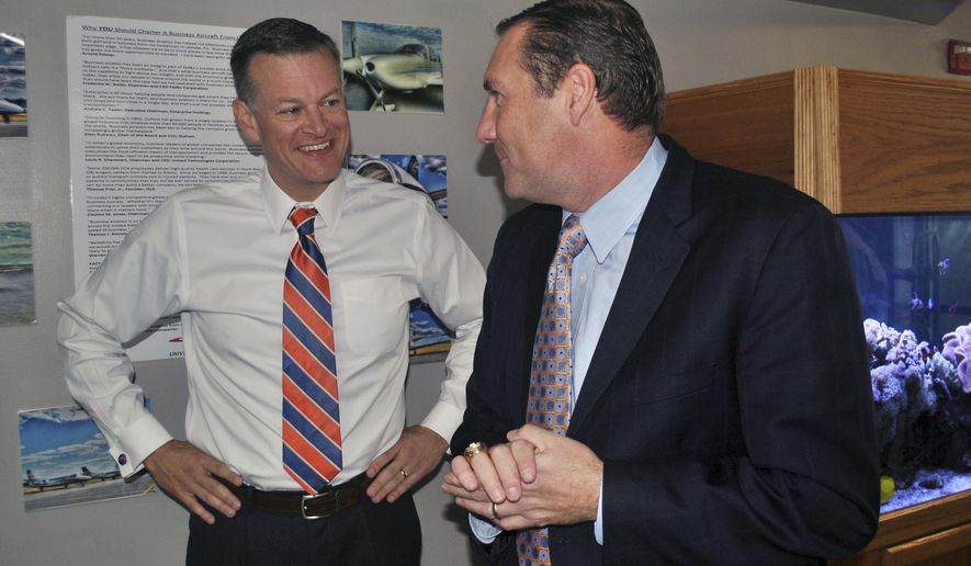 FILE - In this Monday, Nov. 27, 2017 file photo, University of Florida athletic director Scott Stricklin, left, smiles as he talks to Florida&#39;s new NCAA college football coach Dan Mullen after Mullen arrived at the airport in Gainesville, Fla. Making the home-run hire seems to be more difficult than ever for schools searching for a new head football coach. Scott Stricklin moved quickly to hire one of the few proven coaches available this year in Dan Mullen, who during nine years at Mississippi State had become maybe the most successful coach the program has had. (AP Photo/Mark Long, File)