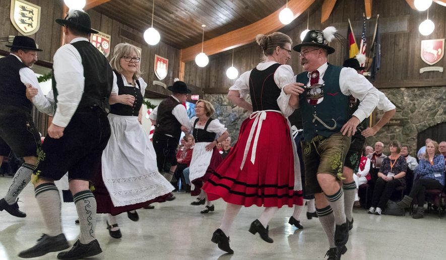 Dancers including Cheri Freuhaut, Jynell Brockhaus and Frank Freihaut, perform for tourist from Minnesota, Wisconsin, and Illinois who arrived in busses take part in the Christmas in Germany program at the German-American Society on Dec. 7, 2017 in Omaha, Neb.  Tourists wanting to experience the holidays around the world are finding festivities in Omaha.  Motorcoach tours from across the country converged on the city for a smattering of Christmas festivities, and local businesses and hoteliers are seeing the boost in a time of year when some hotel rooms sit empty.  (Brendan Sullivan/Omaha World-Herald via AP)