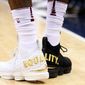 Cleveland Cavaliers forward LeBron James played the first half on Sunday with one white shoe and one black shoe emblazoned with &quot;EQUALITY&quot; on both.