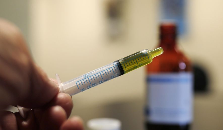 FILE - In this Nov. 6, 2017, file photo, a syringe loaded with a dose of CBD oil is shown in a research laboratory at Colorado State University in Fort Collins, Colo. A small-business owner in Idaho is currently fighting with local officials in the staunchly anti-marijuana state that he should be allowed to sell CBD oil. (AP Photo/David Zalubowski, File)