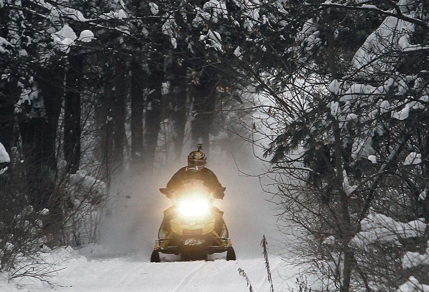 FILE - In this Dec. 31, 2012 file photo, a snowmobile travels a newly-groomed trail in East Montpelier, Vt. With plenty of fresh snow covering much of northern New England, the 2017 winter snowmobile season is off to a good start. (AP Photo/Toby Talbot, File)
