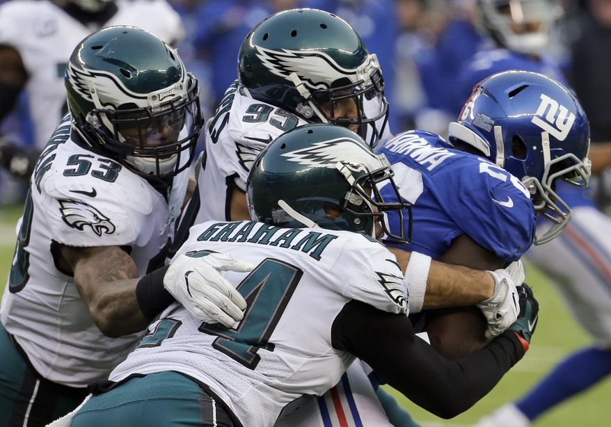 New York Giants running back Orleans Darkwa, right, runs with the ball as Philadelphia Eagles outside linebacker Nigel Bradham (53), outside linebacker Mychal Kendricks (95) and defensive back Corey Graham (24) try to bring him down during the second half of an NFL football game Sunday, Dec. 17, 2017, in East Rutherford, N.J. (AP Photo/Seth Wenig)