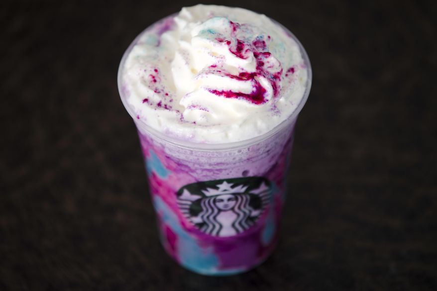 FILE - In this April 20, 2017, file photo, a Starbucks Unicorn Frappuccino is displayed in Philadelphia. It “magically” started as a purple drink with swirls of blue and a first taste that is sweet and fruity, according to the company. (AP Photo/Matt Rourke, File)