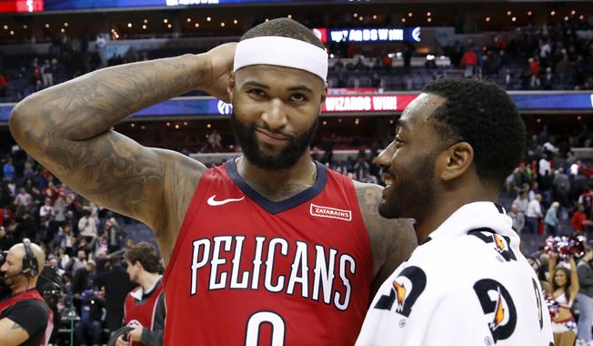New Orleans Pelicans center DeMarcus Cousins, left, reacts as he talks with Washington Wizards guard John Wall after an NBA basketball game Tuesday, Dec. 19, 2017, in Washington. The Wizards won 116-106. (AP Photo/Alex Brandon)