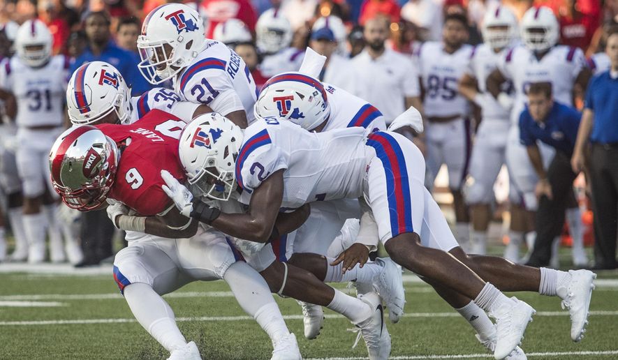 FILE - In this Sept. 16, 2017, file photo, Western Kentucky wide receiver Xavier Lane (9) is tackled by a group of Louisiana Tech players during an NCAA college football game in Bowling Green, Ky. Louisiana Tech takes on SMU in the Frisco Bowl on Dec. 20. (Austin Anthony/Daily News via AP, File)