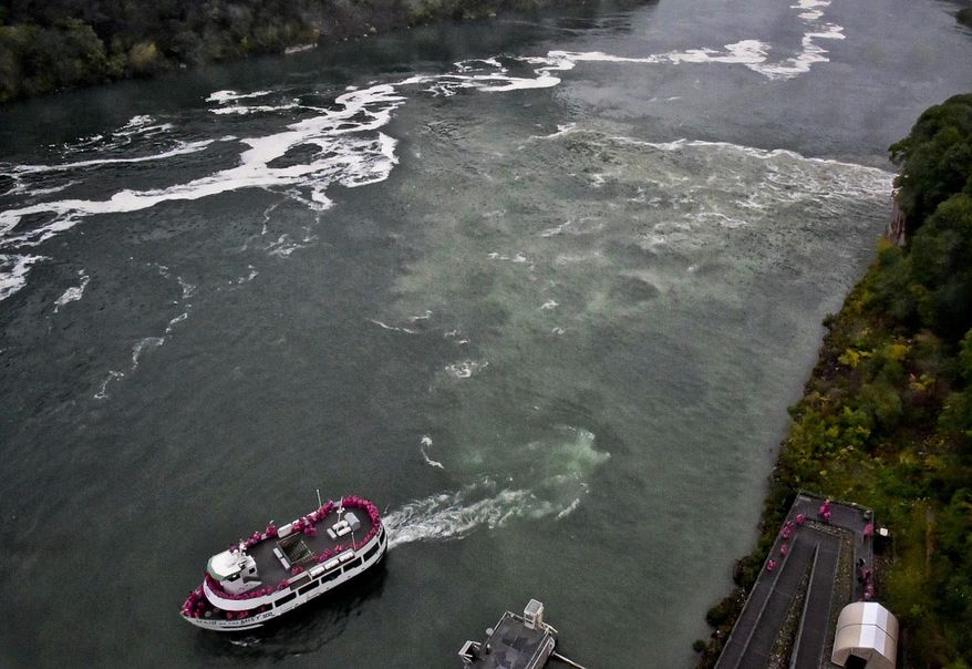 FILE- In this Oct. 9, 2017 file photo, a tour boat travels along the Niagara River in New York, where a series of overflow discharge from a treatment plant have drawn widespread attention. The sewage treatment plant that spewed a smelly black discharge at the base of Niagara Falls during the busy summer tourist season is in line for $20 million in upgrades. Gov. Andrew Cuomo proposed the state investment Tuesday, Dec. 19 as one of his 2018 priorities. (James Neiss /The Niagara Gazette via AP, File)