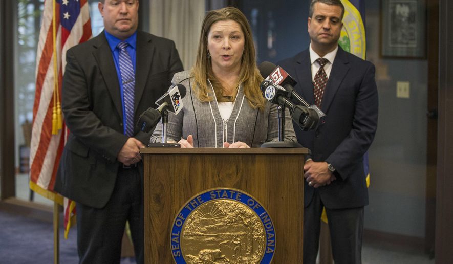 Elkhart prosecutor Vicki Becker, center, speaks in front of Detective Scott Hauser, left, and Detective Steve Price during a press conference regarding an August 2017 triple fatal hit and run incident on Tuesday, Dec. 19, 2017, inside the prosecutor's office in Elkhart, Ind. A northern Indiana woman and her husband were charged Tuesday in an August hit-and-run that killed two children and an adult. (Robert Franklin/South Bend Tribune via AP)