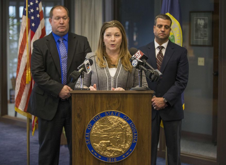 Elkhart prosecutor Vicki Becker, center, speaks in front of Detective Scott Hauser, left, and Detective Steve Price during a press conference regarding an August 2017 triple fatal hit and run incident on Tuesday, Dec. 19, 2017, inside the prosecutor's office in Elkhart, Ind. A northern Indiana woman and her husband were charged Tuesday in an August hit-and-run that killed two children and an adult. (Robert Franklin/South Bend Tribune via AP)