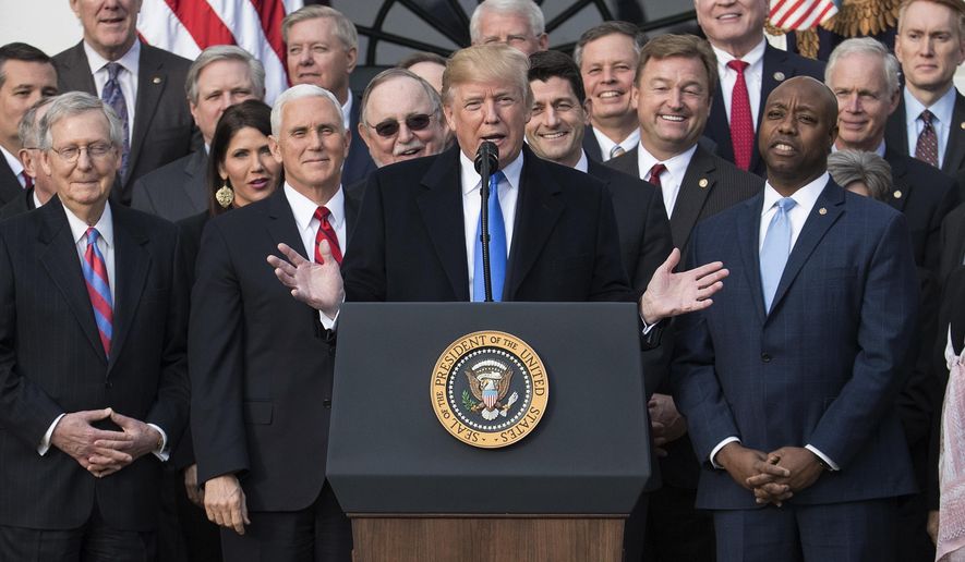 President Donald Trump joined by Senate Majority Leader Mitch McConnell of Ky., Vice President Mike Pence, Speaker of the House Paul Ryan, R-Wis., Sen. Tim Scott, R-S.C., front right, and other members of congress, speaks during an event on the South Lawn of the White House in Washington, Wednesday, Dec. 20, 2017, to acknowledge the final passage of tax overhaul legislation by Congress. (AP Photo/Carolyn Kaster)