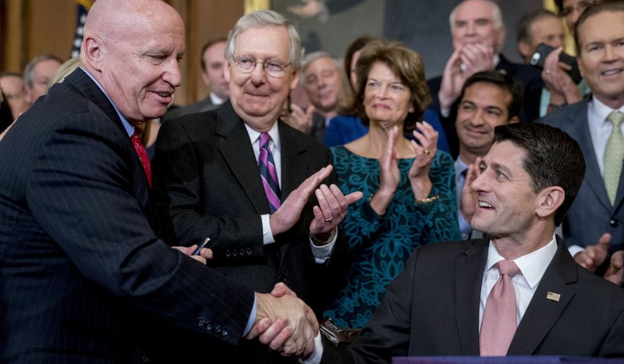 Speaker of the House Paul Ryan, R-Wis., right, shakes hands after presenting a pen to House Ways and Means Committee Chairman Kevin Brady, R-Texas, left, as Senate Majority Leader Mitch McConnell, R-Ky., second from left, watches after signing the final version of the GOP tax bill during an enrollment ceremony at the Capitol in Washington, Thursday, Dec. 21, 2017. (AP Photo/Andrew Harnik)