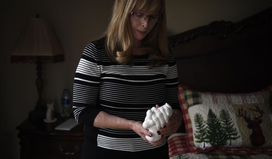 Susan Huschle, whose husband, Kurt, used the aid-in-dying law as a terminal cancer patient on July 16, 2017, speaks about the tiring process of losing her husband. It proved difficult as the drugs took far longer to act than the couple anticipated. Huschle holds a sculpture of her and Kurt&#39;s hands that was made before his death.(AAron Ontiveroz/The Denver Post via AP)