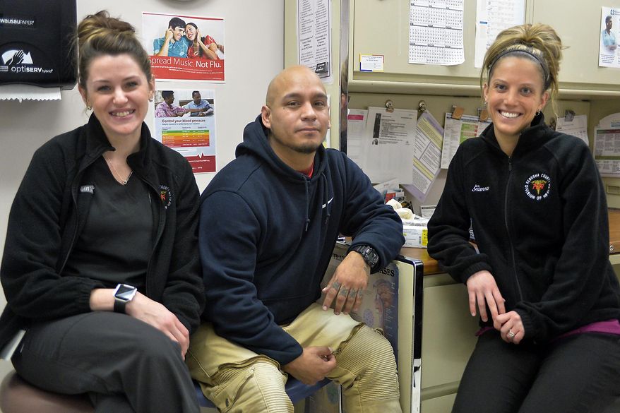 Labiano Valdez, center, sits with public health nurses Amanda Tuura, R.N., left, and Gianna Ventura, R.N., right, at the Kenosha County health department clinic in Kenosha, Wis., on Thursday, Dec. 7, 2017. Valdez is part of the county's Vivitrol program, which has helped him overcome his heroin addiction. (Brian Passino/The Kenosha News via AP)