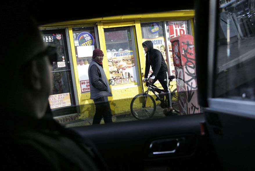 In this Tuesday, Dec. 19, 2017 photo, Sgt. Timothy Cecchini keeps an eye on the street while cruising with other neighborhood coordinating officers in the Brooklyn borough of New York. Even after two terrorist attacks and a motorist’s deadly rampage through Times Square, New York City is on track to smash its modern-era low for homicides. (AP Photo/Seth Wenig)