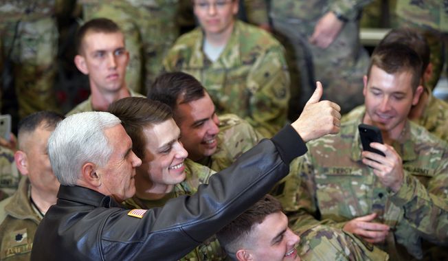 U.S. Vice President Mike Pence poses for photos with troops at Bagram Air Base in Afghanistan on Thursday, Dec. 21, 2017. (Mandel Ngan/Pool via AP)