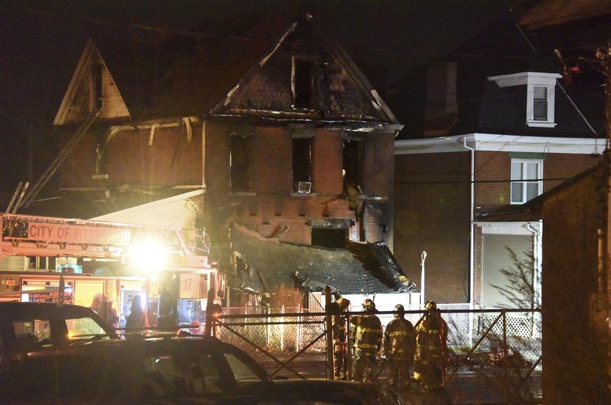 City of Pittsburgh Firefighters gather along Bennett Street in front of the fatal scene of the triple fatal fire, Wednesday Dec. 20, 2017, in the Homewood neighborhood of Pittsburgh. (Darrell Sapp/Post-Gazette)/Pittsburgh Post-Gazette via AP)
