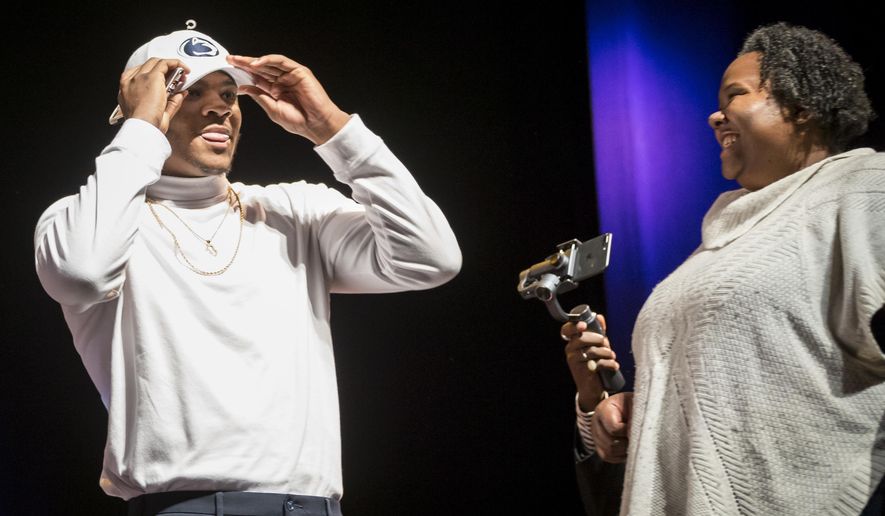 Harrisburg High School defensive end Micah Parsons dons a Penn State hat announcing his intentions to attend the school during the NCAA college football early signing period, Wednesday, Dec. 20, 2017, in Harrisburg, Pa. (Joe Hermitt/PennLive.com via AP)
