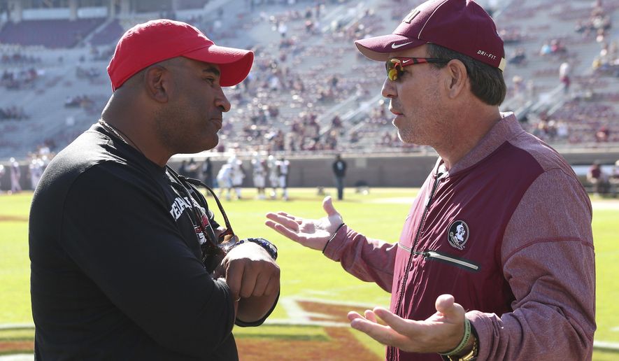 FILE - In this Nov. 18, 2017, file photo, Florida State's head coach Jimbo Fisher, right, meets Delaware State's head coach Kenny Carter at midfield before the start of an NCAA college football game in Tallahassee Fla. The latest issue in a mostly forgettable season for Florida State is a possible administrative error, apparently discovered by a Reddit user, that calls into question the Seminoles' bowl eligibility. The Independence Bowl between Florida State and Southern Miss will go on, regardless, and Seminoles fans can only hope that they can finally put 2017 to rest.(AP Photo/Steve Cannon, File)