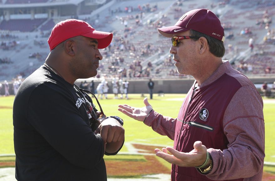 FILE - In this Nov. 18, 2017, file photo, Florida State's head coach Jimbo Fisher, right, meets Delaware State's head coach Kenny Carter at midfield before the start of an NCAA college football game in Tallahassee Fla. The latest issue in a mostly forgettable season for Florida State is a possible administrative error, apparently discovered by a Reddit user, that calls into question the Seminoles' bowl eligibility. The Independence Bowl between Florida State and Southern Miss will go on, regardless, and Seminoles fans can only hope that they can finally put 2017 to rest.(AP Photo/Steve Cannon, File)