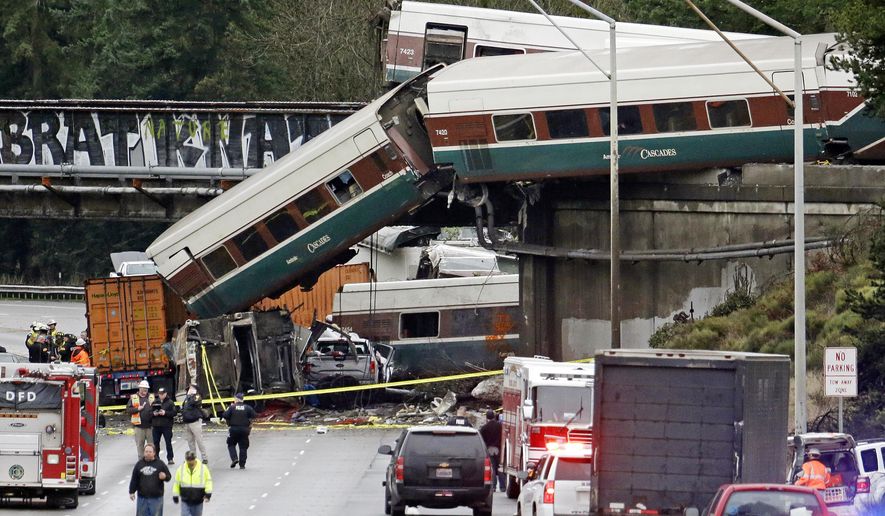 FILE - In this Dec. 18, 2017 file photo, cars from a derailed Amtrak train spill onto Interstate 5 in DuPont, Wash. On Friday, Dec. 22, 2017, The Associated Press reported that stories circulating on the internet that an anarchist group was responsible for the accident are untrue. (AP Photo/Elaine Thompson, File)