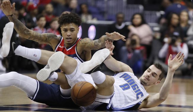 Washington Wizards forward Kelly Oubre Jr., left, competes for a loose ball with Orlando Magic guard Mario Hezonja, from Croatia, during the first half of an NBA basketball game Saturday, Dec. 23, 2017, in Washington. (AP Photo/Alex Brandon)