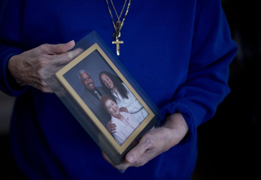 In this Jan. 11, 2017, photo, a person holds a photo of Karen Batts, pictured at right, in Oregon. Batts died of hypothermia in a parking garage in Portland, Ore. (Beth Nakamura/The Oregonian via AP)