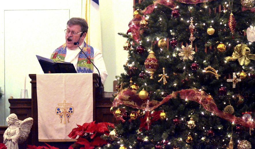 Rev. Jeff Stoll sings a Christmas hymn during a Christmas Eve service at First Covenant Church in Saybrook Township, Ohio, on Sunday evening, Dec. 24, 2017. (Warren Dillaway/The Star-Beacon via AP)