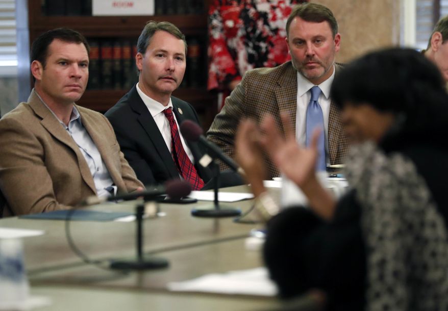 FILE - In this Dec. 19, 2017, file photo, House Medicaid Committee Republican members, from left, Chris Johnson of Hattiesburg, Sam Mims of McComb, Jason White of West, listen as Rep. Omeria Scott, D-Laurel, foreground, questions a health care association director during a Medicaid hearing, at the Capitol in Jackson, Miss. Mississippi legislators in 2018 are expected to bicker over Medicaid, a government health insurance program that consumes a large portion of the state budget and covers about 1 in every 4 residents. (AP Photo/Rogelio V. Solis, File)