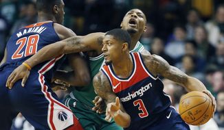 Washington Wizards&#39; Bradley Beal (3) drives past Boston Celtics&#39; Marcus Smart, behind, during the first quarter of an NBA basketball game in Boston, Monday, Dec. 25, 2017. (AP Photo/Michael Dwyer)