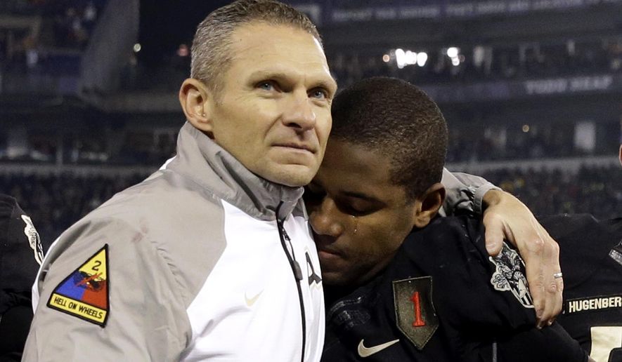 FILE - In this Dec. 13, 2014, file photo, Army head coach Jeff Monken, left, embraces running back Larry Dixon after losing 17-10 to Navy in an NCAA college football game, in Baltimore. Monken’s second season at Army in 2015 ended with 10 losses and a record 14th straight defeat to Navy. While it pointed to more of the same for a struggling program, Monken was confident a West Point turnaround was imminent thanks to successful recruiting and the number of close losses.Monken was proven right. (AP Photo/Patrick Semansky, File)