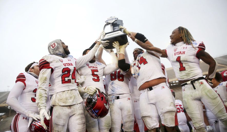 Utah football players hold up their championship trophy after winning the Zaxby&#x27;s Heart of Dallas Bowl against West Virginia at Cotton Bowl Stadium in Dallas on Tuesday, Dec. 26, 2017. Utah won 30-14. (Rose Baca/The Dallas Morning News via AP)