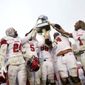 Utah football players hold up their championship trophy after winning the Zaxby&#x27;s Heart of Dallas Bowl against West Virginia at Cotton Bowl Stadium in Dallas on Tuesday, Dec. 26, 2017. Utah won 30-14. (Rose Baca/The Dallas Morning News via AP)