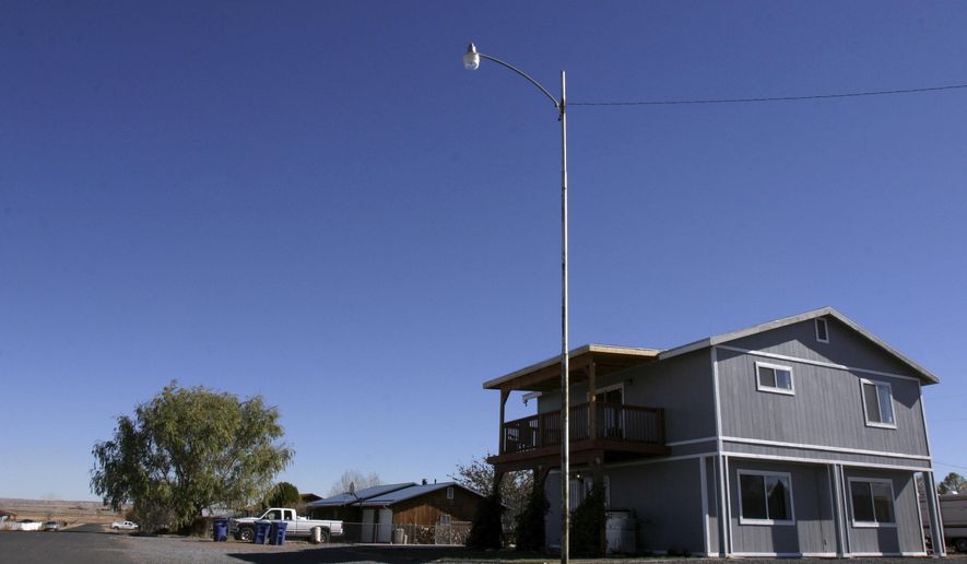 FILE - This Nov. 8, 2008, file photo shows the house in St. Johns, Ariz., where Vincent Romero and Timothy Romans, of San Carlos, Ariz., were found fatally shot. Police said Romero's 9-year-old son, who was 8 at the time, used a rifle to shoot the men as they returned home from work. A judge overseeing the case of the now teenager, who was charged in a double homicide when he was 8 years old, heaped praise on him Wednesday, Dec. 27, 2017, for the progress he's made. He turns 18 on Friday, marking the end of probation. (AP Photo/Dana Felthauser, File)