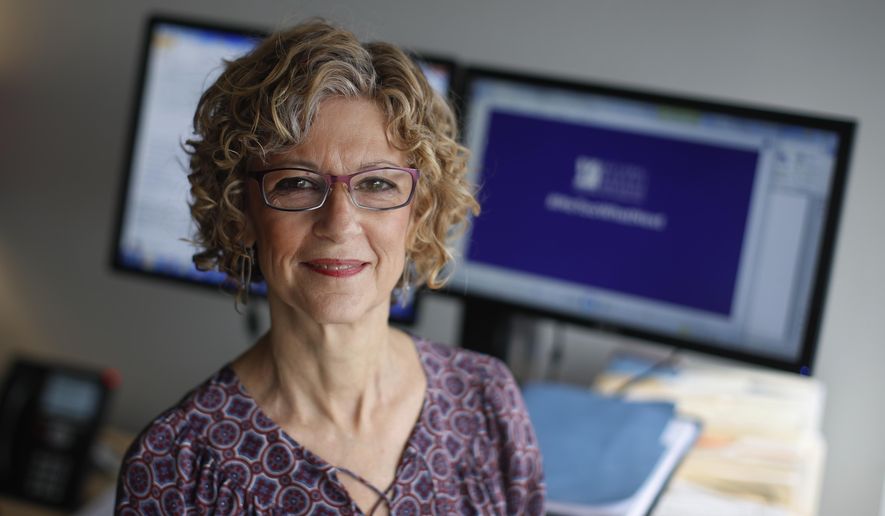 In this Tuesday, Dec. 5, 2017 photo, Karen Schneider, the vice president of communications at the National Women's Law Center, poses for a photo in National Women's Law Center offices in Washington. In 1979, Schneider was a copy editor in her 20s, aspiring to a journalism career, when a senior editor at her newspaper forcibly kissed her after late-night drinks with colleagues. "I didn’t know what sexual harassment was, I didn’t know that what he did was actually illegal," she recalled in a recent phone interview. (AP Photo/Carolyn Kaster)