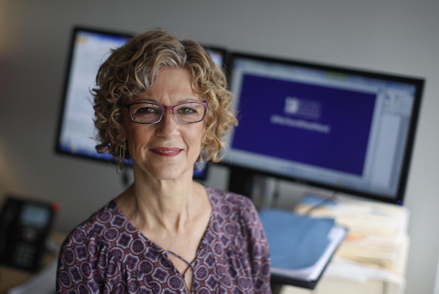 In this Tuesday, Dec. 5, 2017 photo, Karen Schneider, the vice president of communications at the National Women's Law Center, poses for a photo in National Women's Law Center offices in Washington. In 1979, Schneider was a copy editor in her 20s, aspiring to a journalism career, when a senior editor at her newspaper forcibly kissed her after late-night drinks with colleagues. "I didn’t know what sexual harassment was, I didn’t know that what he did was actually illegal," she recalled in a recent phone interview. (AP Photo/Carolyn Kaster)