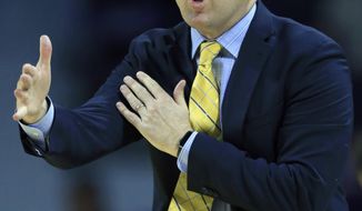 FILE - In this Nov. 20, 2017, file photo, Northern Arizona head coach Jack Murphy directs his team during the first half of an NCAA college basketball game against Kansas State, in Manhattan, Kan. The top programs in college basketball have state-of-the-art practice facilities and play in arenas that would make some pro teams jealous. At the low end of Division I basketball, the workout rooms can be a haphazard array of random weights and the gym of the bandbox variety, often not even on campus. (AP Photo/Orlin Wagner, File)