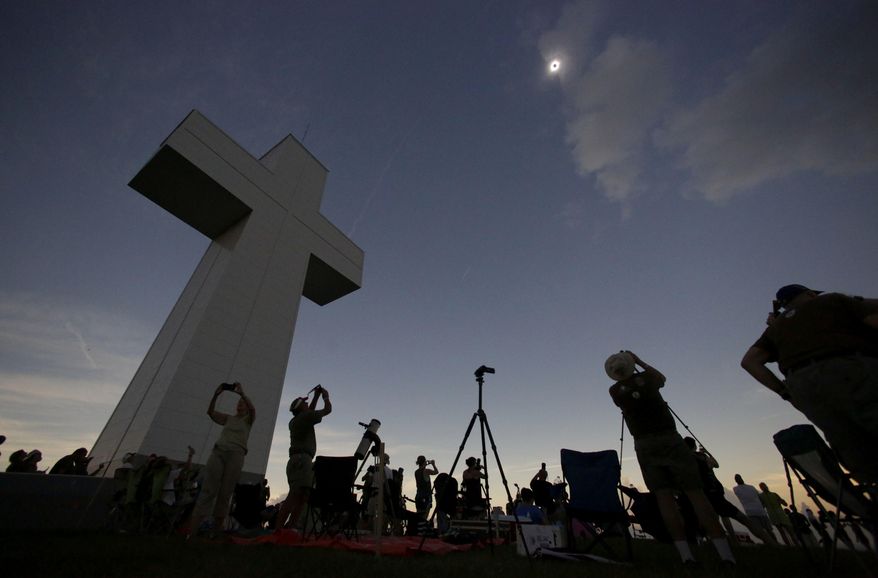 File - in this Aug. 21, 2017 file photo, a total solar eclipse is seen above the Bald Knob Cross of Peace in Alto Pass, Ill. More than 700 people visited the over 100 foot cross for the event. The first total solar eclipse to sweep coast-to-coast across the U.S. in 99 years drew hundreds of thousands of people to areas of southern Illinois located in the path of totality, where the sun is 100 percent blocked by the sun. The story was chosen as one of Associated Press year's 10 biggest stories or 2017 in Illinois. (AP Photo/Charles Rex Arbogast File)