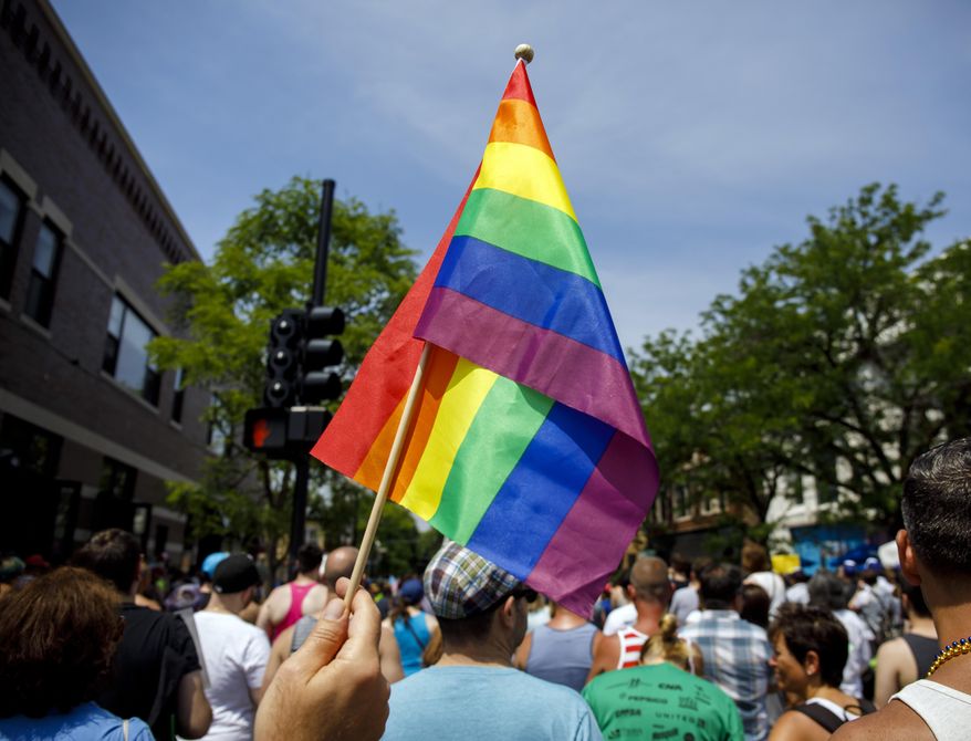FILE - In this June 11, 2017 file photo people attend the LGBTQ Chicago Equality rally in the Andersonville neighborhood of Chicago. Starting in January 2018, Illinois is outlawing a rare criminal defense argument allowing the use of a victim's sexual orientation as justification for violent crime. It's a ban that gay rights advocates hope to replicate in about half a dozen states next year. Illinois follows California in outlawing the so-called "gay panic defense." It isn't common, but one study shows it's surfaced in roughly half of U.S. states since the 1960s. (Brian Cassella/Chicago Tribune via AP File)