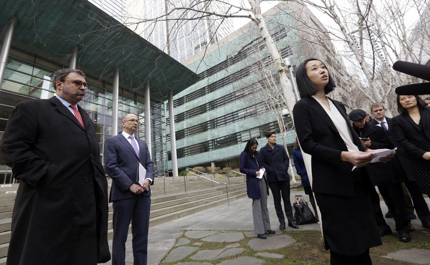 FILE- In this Dec. 21, 2017, file photo, Mariko Hirose, right, a litigation director at the Urban Justice Center, addresses reporters as Mark Hetfield, president & CEO of HIAS, left, and Rabbi Will Berkowitz, Jewish Family Service of Seattle CEO, look on in front of a federal courthouse after speaking with media in Seattle. The government has asked a federal judge to change his order that partially lifted a Trump administration refugee ban. (AP Photo/Elaine Thompson, File)