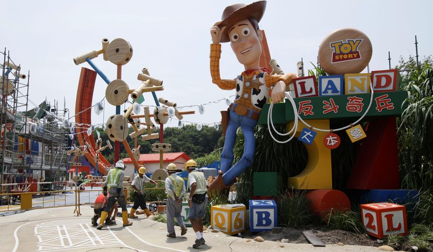 FILE - In this Sept. 8, 2011, file photo, workers walk past "Toy Story" character Woody at the construction site of the new attraction area Toy Story Land in Hong Kong Disneyland. A new 11-acre Toy Story Land is planned for Walt Disney World Resort near Orlando, Fla., in 2018, opening at the theme park's Hollywood Studios. (AP Photo/Kin Cheung, File)