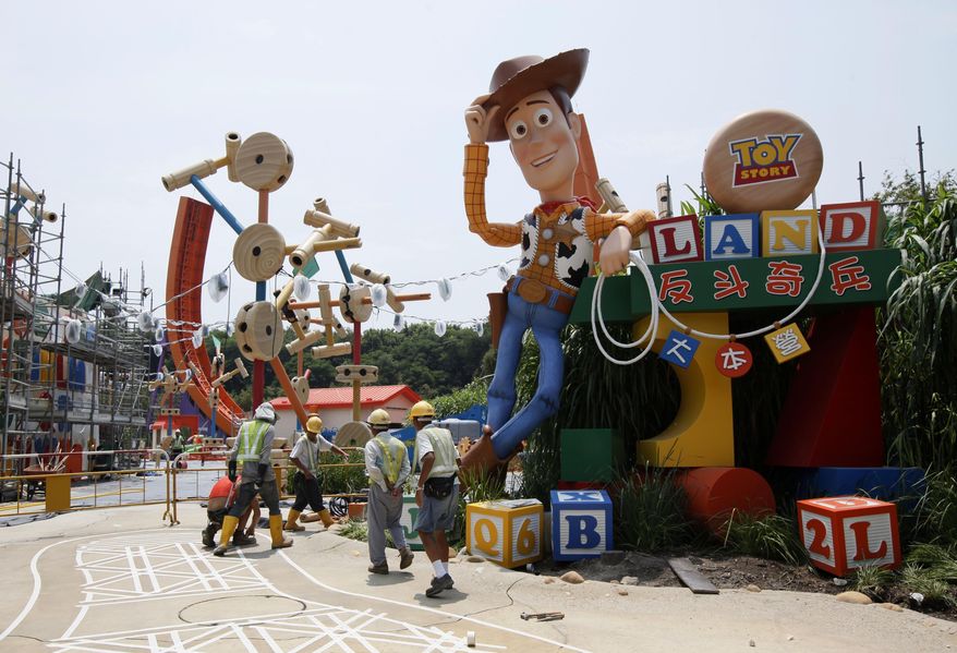 FILE - In this Sept. 8, 2011, file photo, workers walk past "Toy Story" character Woody at the construction site of the new attraction area Toy Story Land in Hong Kong Disneyland. A new 11-acre Toy Story Land is planned for Walt Disney World Resort near Orlando, Fla., in 2018, opening at the theme park's Hollywood Studios. (AP Photo/Kin Cheung, File)