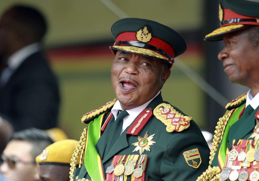 FILE - In this Friday, Nov. 24, 2017 file photo, Army General Constantino Chiwenga smiles during the presidential inauguration ceremony in the capital Harare, Zimbabwe. Zimbabwe's state-run media is reporting that new President Emmerson Mnangagwa has appointed the country's former military commander as one of his two vice presidents. The naming of Constantino Chiwenga deepens concerns among some in the southern African nation about the military's close ties with Mnangagwa, who took power last month after Chiwenga led a military takeover to oust longtime leader Robert Mugabe. (AP Photo/Tsvangirayi Mukwazhi, File)