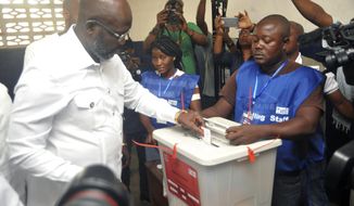 Former soccer star George Weah, Presidential candidate for the Coalition for Democratic Change, casts his vote during a Presidential runoff election in Monrovia, Liberia, Tuesday Dec. 26, 2017, Young Liberians went straight from all-night Christmas celebrations to the polls Tuesday for a runoff election between a former international soccer star and the vice president to replace Africa&#39;s first female head of state. (AP Photo/Abbas Dulleh)